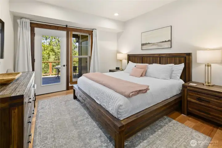 Primary bedroom on main floor with door out to back patio