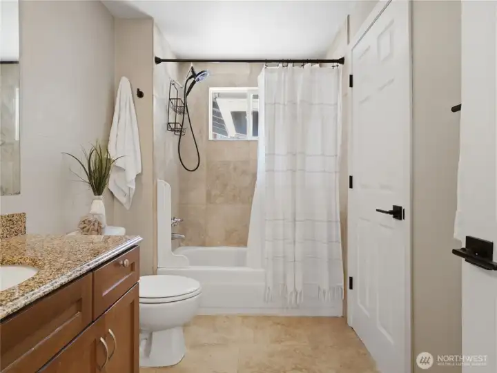 Beautifully updated full bathroom with travertine floors and surround. Second door connecting to bedroom that could be used as the primary bedroom as well.