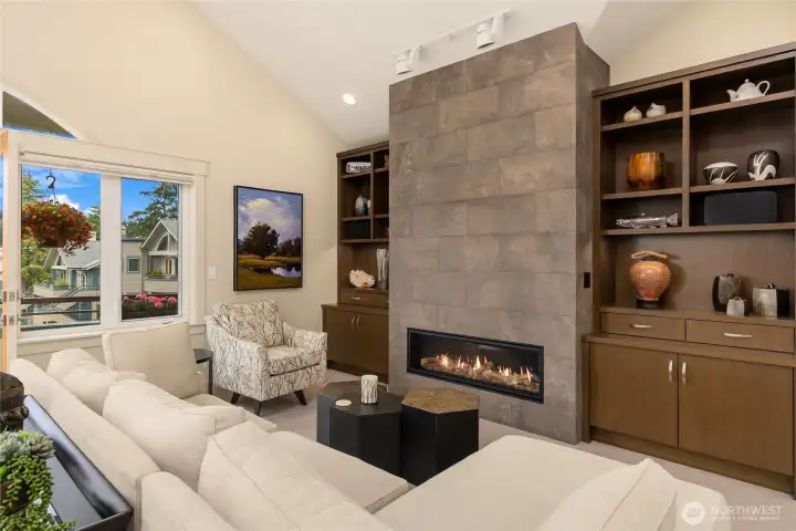 The living room features a striking tile-surround fireplace flanked by beautiful custom cabinetry