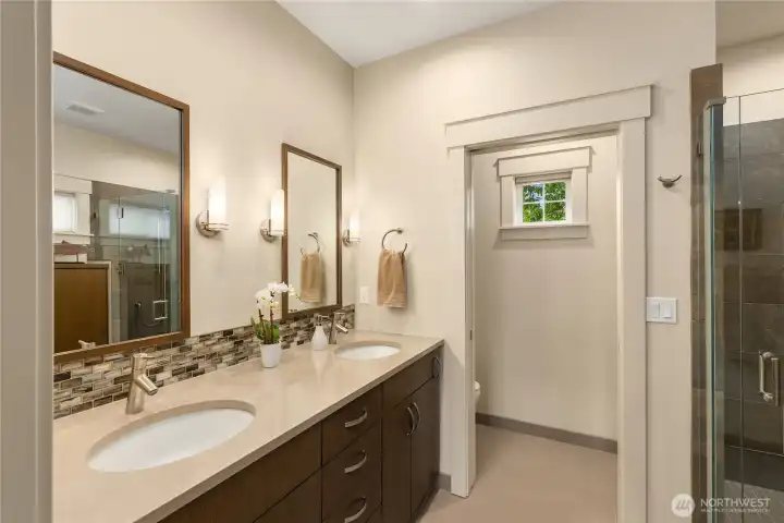 An ensuite bathroom enjoys double sinks in a beautiful custom vanity, private water closet...