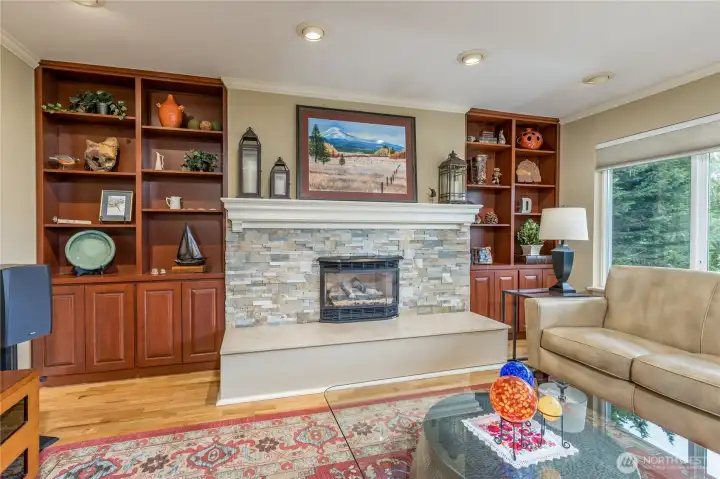 Classic architectural charm meets modern living with this stately stone fireplace and custom built-in cabinetry.