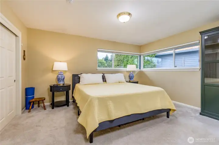 Spacious main-level primary retreat featuring dual closets and oversized corner windows.