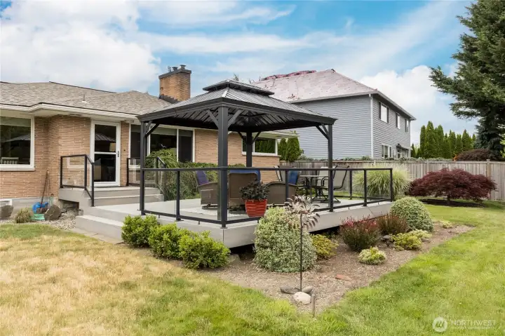 This beautiful composite deck, complete with a stylish metal gazebo, is the ultimate space for relaxing or hosting summer gatherings.