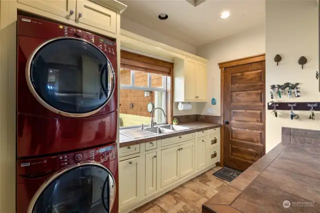 This large main floor utility room just off of the 3 car attached garage. It hosts a full sized washer/dryer, just one of the 4 you'll find onsite!