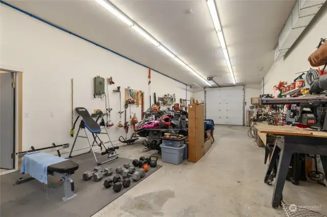 Interior of the shop. This bay hosts a work area & snowmobile storage & also a home gym space.