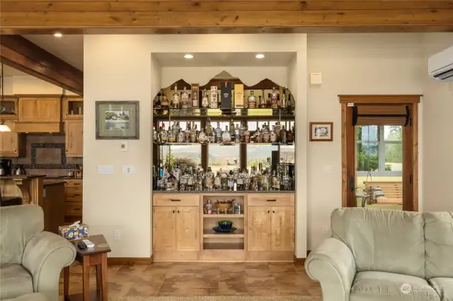 This is an amazing home for entertaining inside & out! This built-in bar featuress custom art honoring the Stuart Mountain Range. To the right you'll see the "cigar room!"