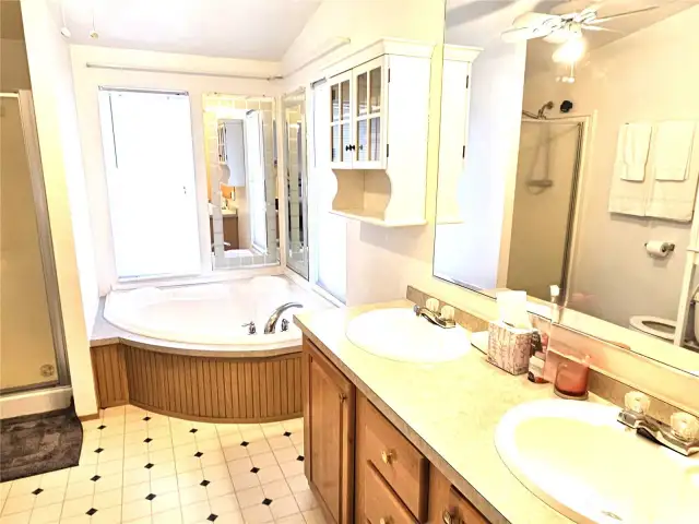 Primary bedroom boasts an ensuite bathroom with a soaking tub, separate shower and double sinks.