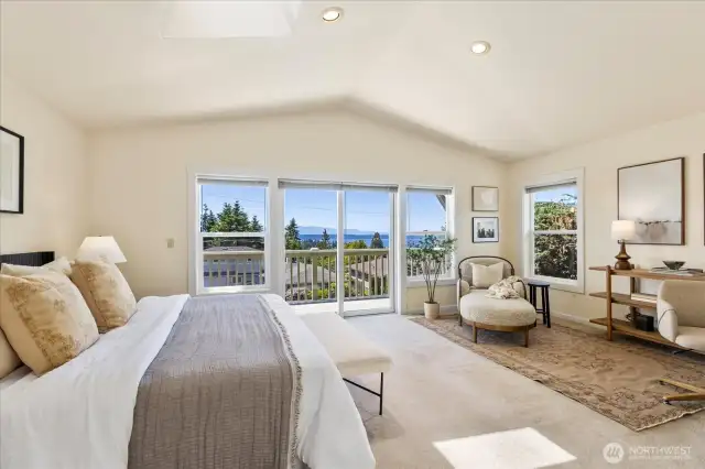 Expansive primary bedroom with vaulted ceilings, deck and water/mountain/sunset views