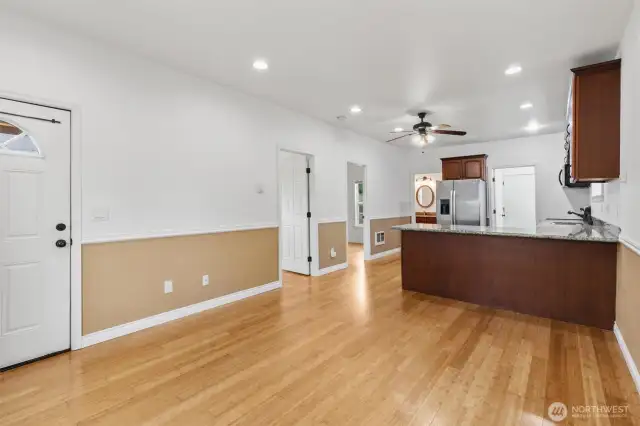 Living room and dining room facing into the remodeled kitchen that boasts slab granite countertops and eating bar.
