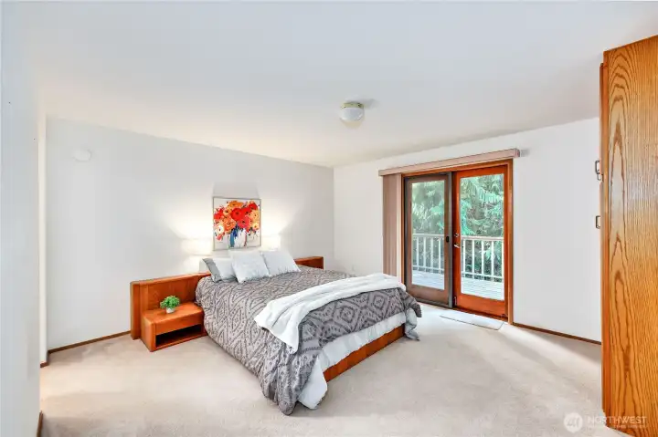 Primary bedroom with door leading out to the deck.