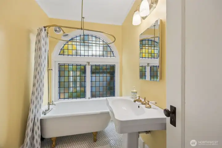 The clawfoot tub and dramatic window are just a few of the period details seen throughout the house.