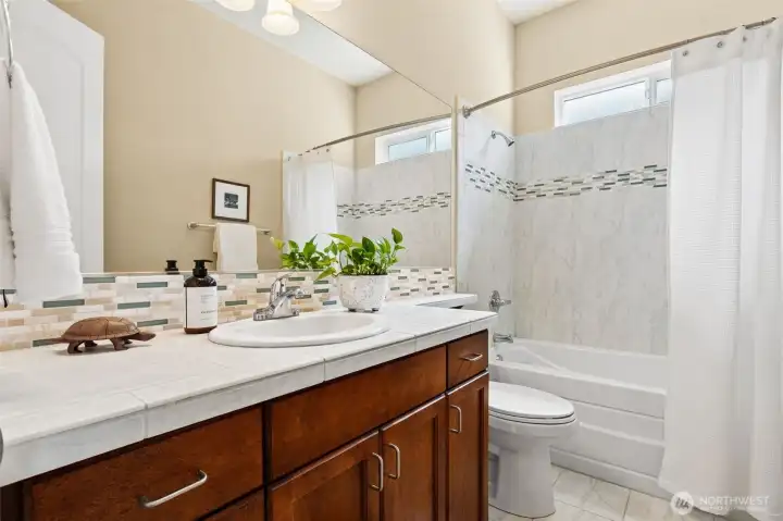 Full bathroom with tile surround adjacent to guest room