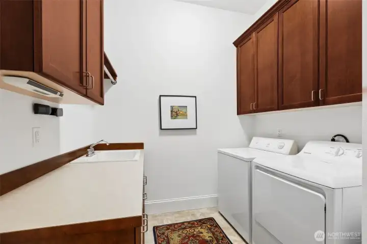 Laundry with sink and storage cabinets. Includes washer and dryer.