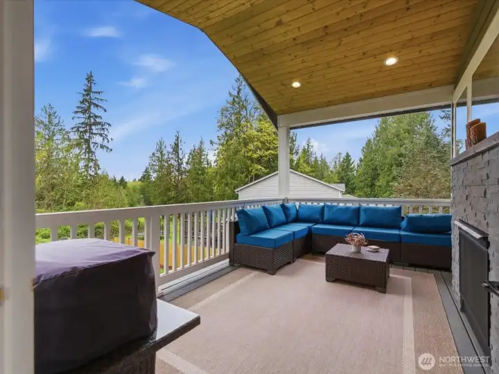 Exceptional covered outdoor living space featuring low-maintenance Trex decking, recessed lighting, and a striking double-sided gas fireplace shared with the great room. Designed for year-round enjoyment and entertaining, this private retreat overlooks peaceful territorial views and seamlessly extends the home’s indoor-outdoor living experience. Exceptional covered outdoor living space featuring low-maintenance Trex decking, recessed lighting, and a striking double-sided gas fireplace shared with the great room. Designed for year-round enjoyment and entertaining, this private retreat overlooks peaceful territorial views and seamlessly extends the home’s indoor-outdoor living experience.