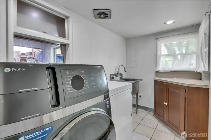 Laundry room includes a utility sink and a convenient folding table for added functionality.