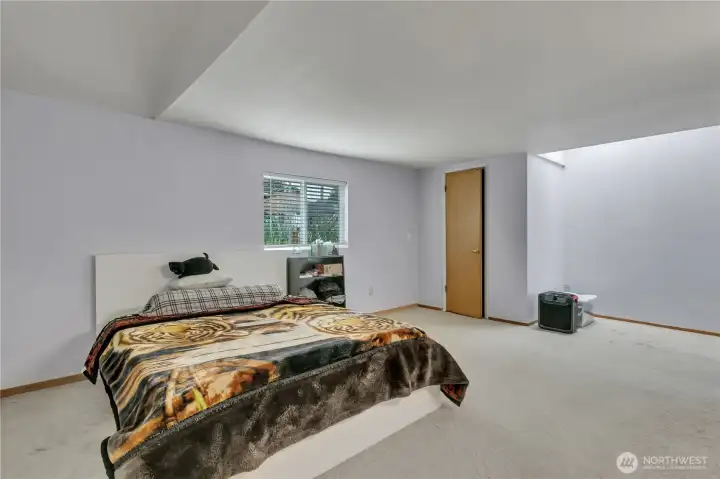 Large primary bedroom with skylights that bring in abundant natural light, leading to a private ¾ en-suite.