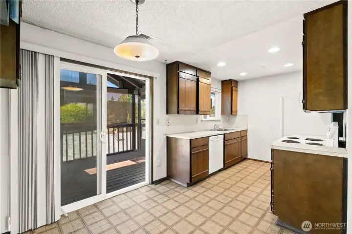 Looking towards the kitchen, dining area and deck from between the dining area and living room