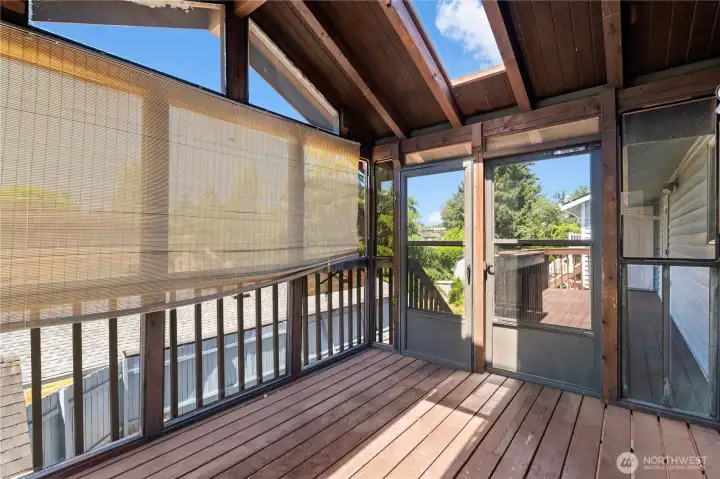 Fully enclosed deck off dining area and kitchen looking towards exterior steps and deck that leads to primary bedroom and 2nd floor storage