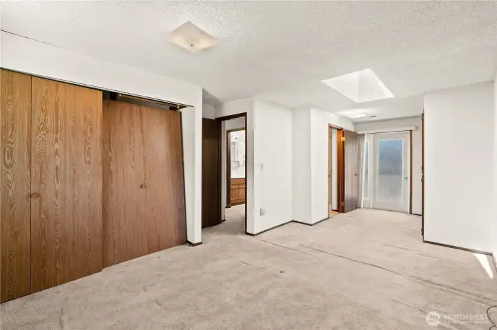 2nd floor primary bedroom with 3/4 bath and exterior door to deck and 2nd floor storage