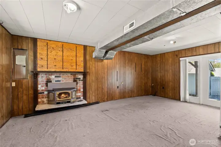 Lower level bonus room looking towards fireplace and backdoor slider/patio (fire in fireplace was digitally added)