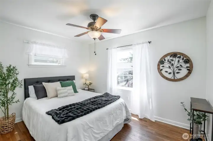 Front bedroom w/ hardwoods, generous bi-fold closet, ceiling fan and all day sun.