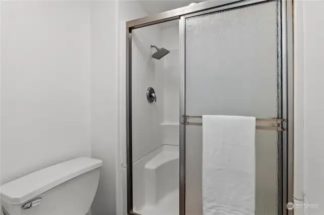Water closet with toilet and shower can be closed off with pocket door.