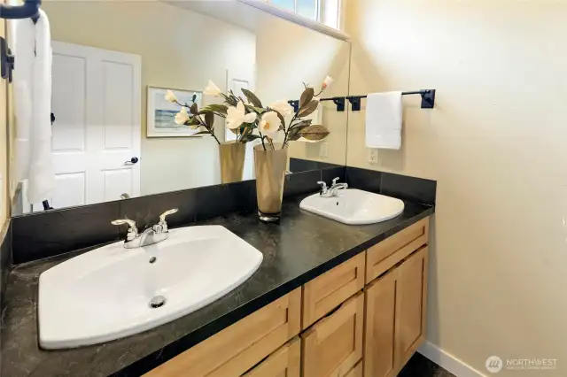The primary suite bath has a two-sink vanity and ample counter space.