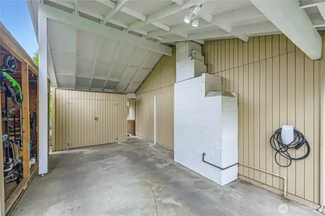 Convenient carport has additional storage and is wired for EV charging.