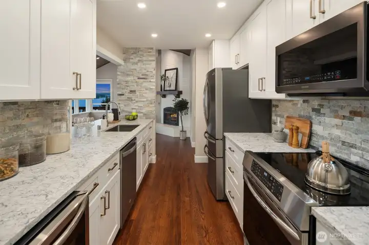 The remodeled kitchen features custom cabinetry, stainless appliances and quartz countertops.