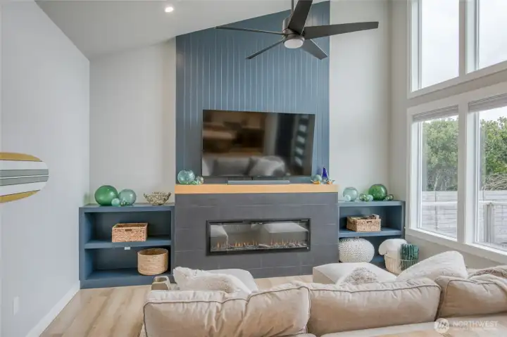 Gorgeous electric fireplace with slate tile, floor to ceiling wood and built-in shelving to display all your beach finds