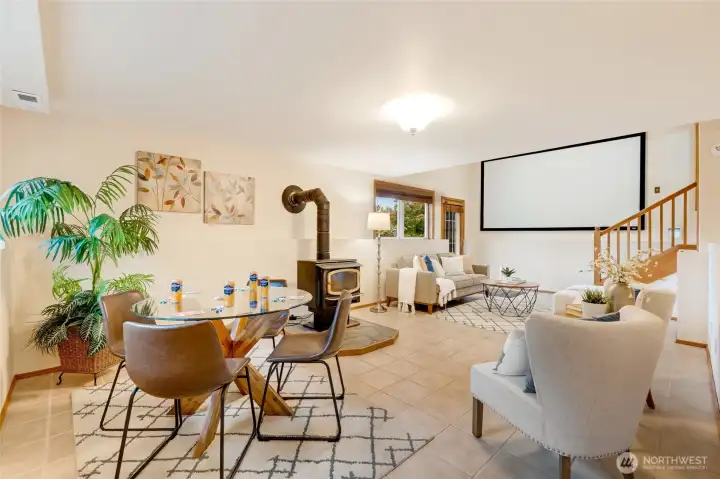 Expansive lower level featuring a wood stove, media screen with projector that stay, and multiple seating areas. Perfect for game nights, movie marathons, or relaxed entertaining.
