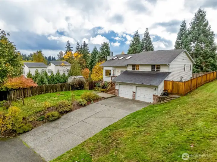 Wide-lot view highlighting the home’s spacious yard, mature greenery, and quiet neighborhood setting. A great blend of privacy and community feel.
