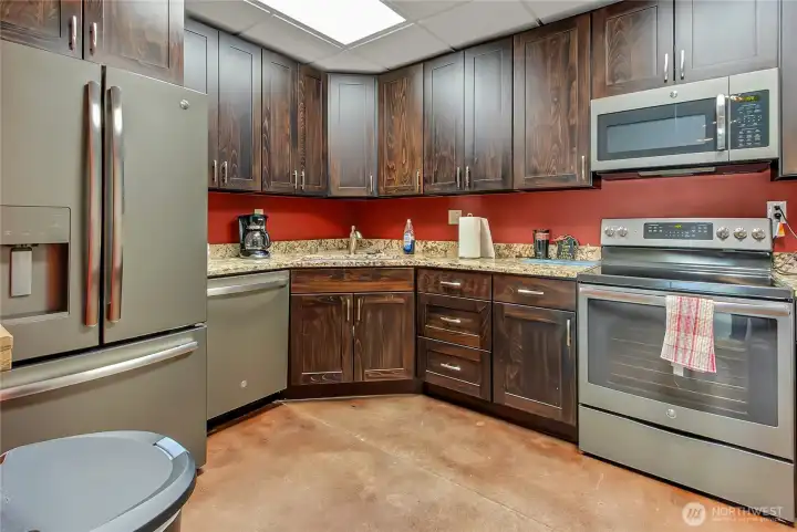 Kitchen with standard size refrigerator, dishwasher, stove and microwave