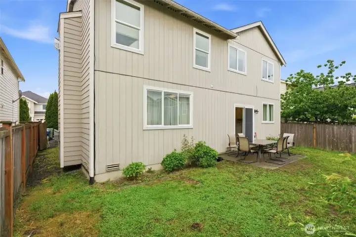 The good-sized flat backyard offers plenty of space for outdoor entertaining, play, and relaxation.