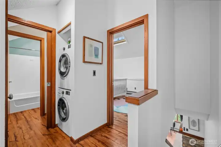 Upper level full bath to the left, stacking washer and dryer, larger bedroom.