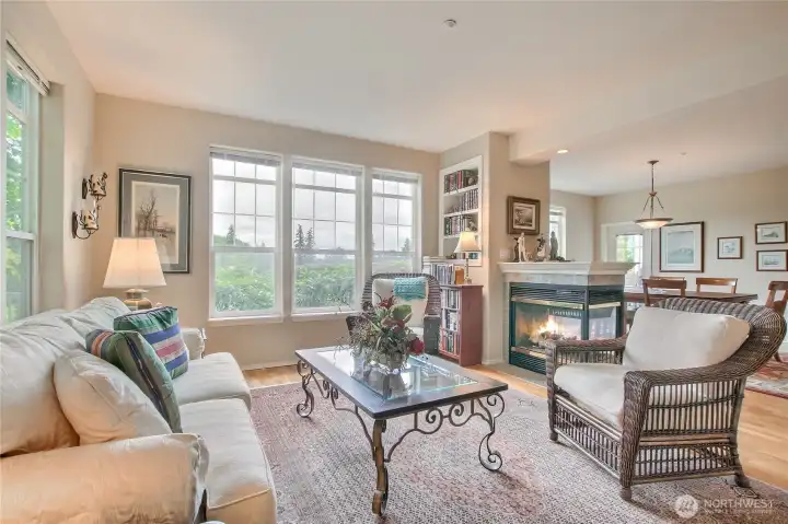 Living room with three sided gas fireplace and formal dining room to the right.