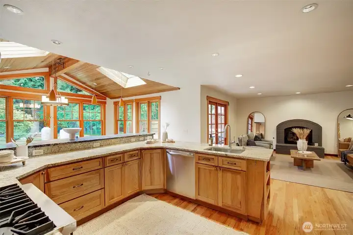 This is the view for the chef or chefs, a party of chefs! Everyone together and enjoying a fire in the fireplace and nature view.. guests sitting at the bar....to coach, chop or chat.
