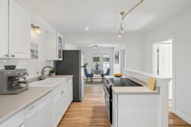 Kitchen has oversized ceramic sink and stainless steel appliances and flows nicely into the eating space.