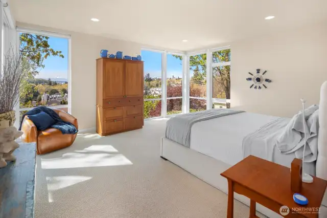 The palatial northwest corner primary suite enjoys more high ceilings and even more sweeping city & mountain views