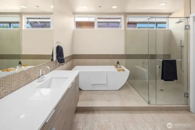A ceiling-mount tub filler, clerestory windows, double sinks mounted under white quartz counters and a huge separate shower are just part of what makes the primary bath a luxurious personal space