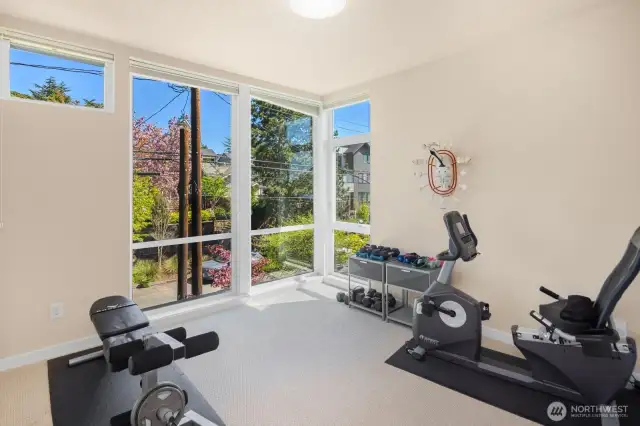 The 2nd of 3 bedrooms on the upper floor offers a flex space perfect for a home gym with an inspiring view