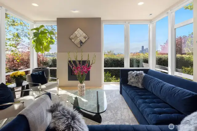 Blond hardwoods, a gas fireplace and floor-to-ceiling windows frame amazing views of the city skyline and Olympic Mountains