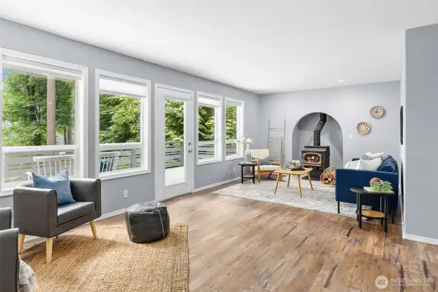 Bright and airy living space featuring expansive windows and access to the front deck.