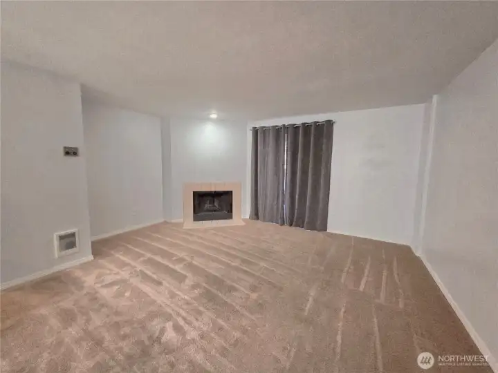 Living room with cBeing on the ground floor keeps this unit cool in the summer, and a wood burning fireplace is a nice option in fall & winter.ozy wood fireplace