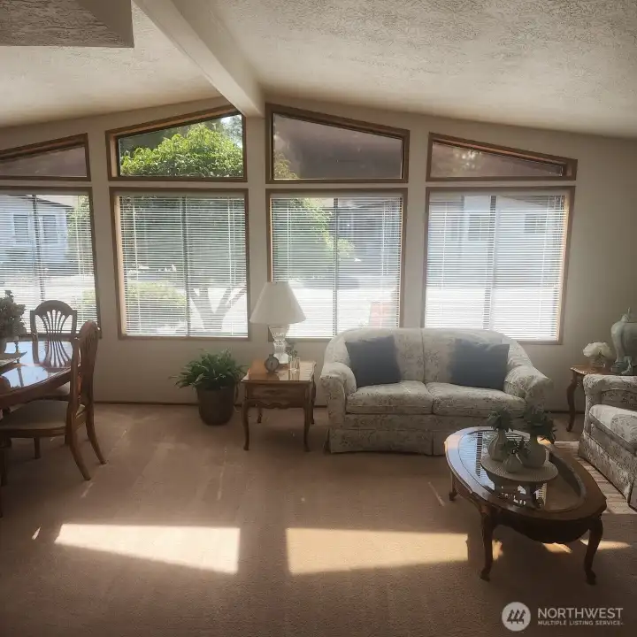 Living room with vaulted ceilings and full of windows.