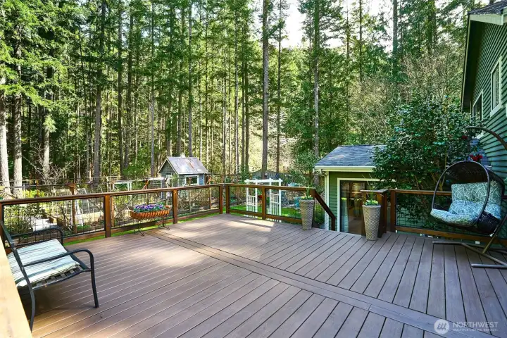 Expansive Timbertech deck framed by lush gardens and mature trees—ideal for relaxing or entertaining outdoors.