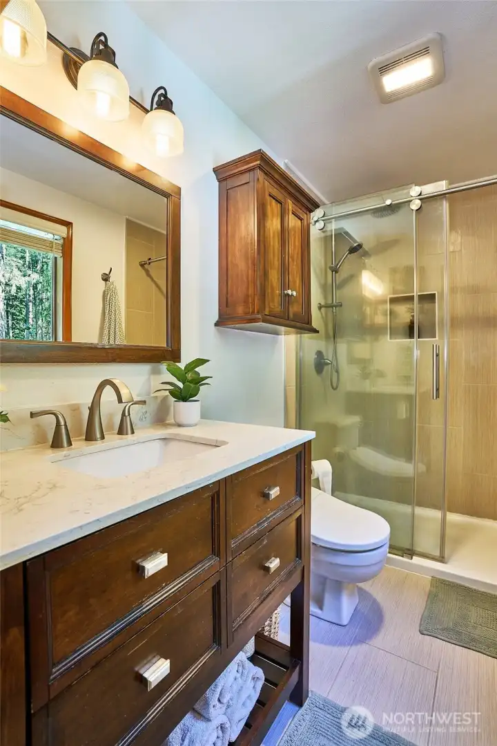 Newly updated primary bathroom featuring stylish tile flooring, a sleek walk-in shower, and modern finishes for a fresh, refined look.
