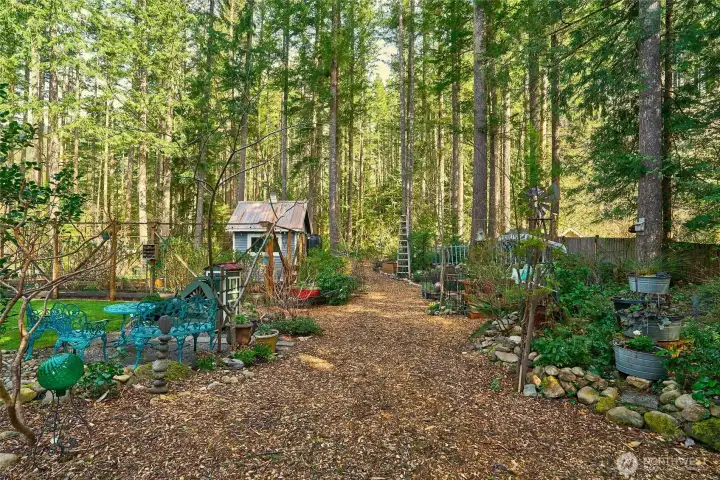Serene path winding around the garden, highlighting the charming potting shed and beautifully landscaped surroundings that blend seamlessly with the natural backdrop.