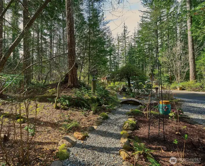 Charming garden paths meander along the side of the house, connecting the backyard to the front and showcasing lush plantings and beautifully maintained landscaping along the way.