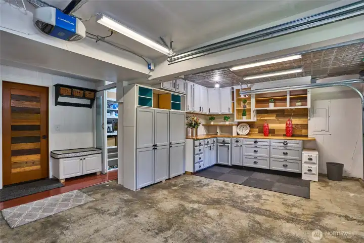 Spacious two-car garage featuring a versatile hobby area and a large walk-in pantry for convenient storage of extra household essentials, still leaving room to park.